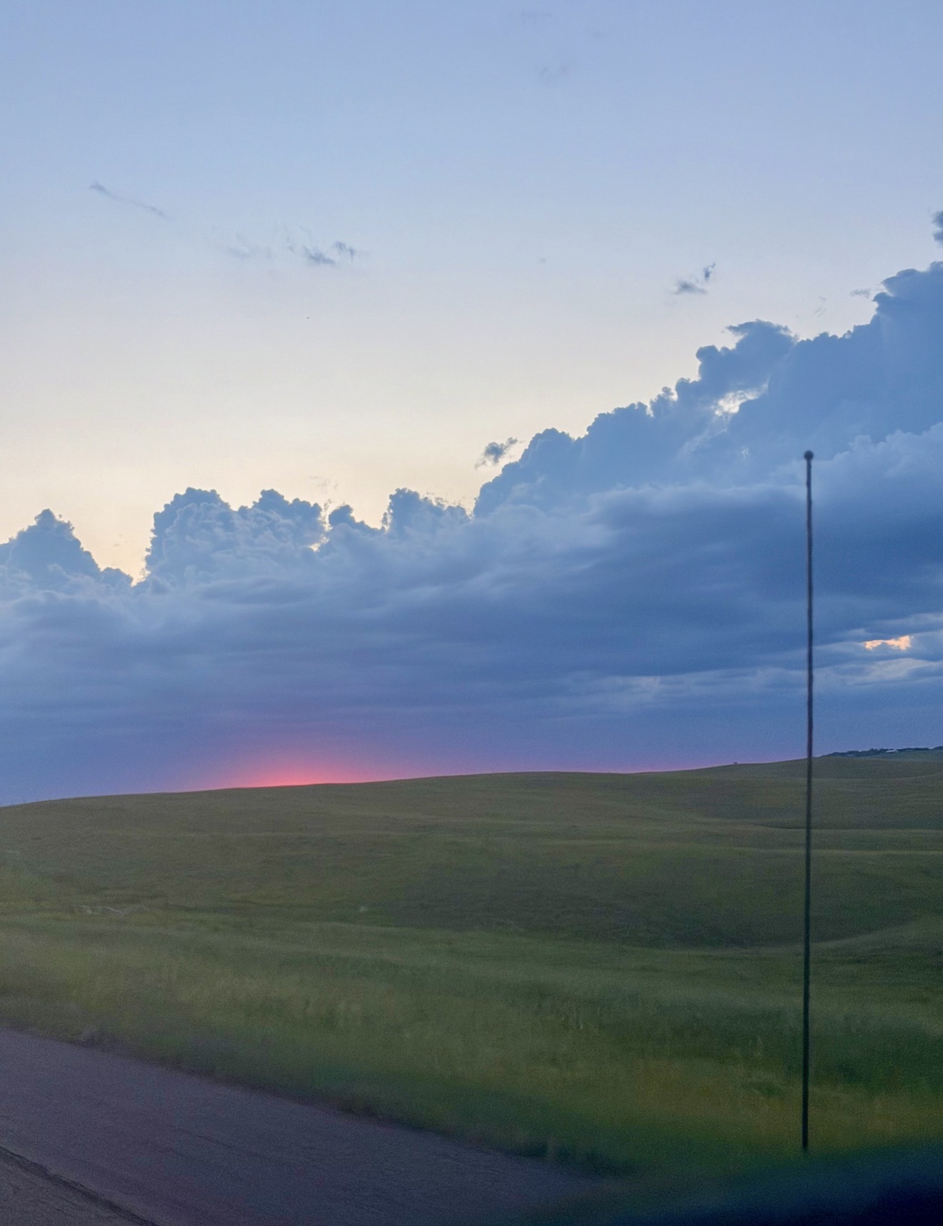 Reference photograph of a South Dakota sunset behind open fields and a slender roadside pole